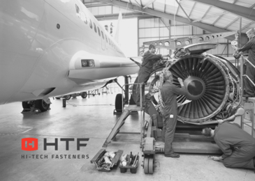  A group of engineers working on an airplane engine with the HTF logo placed in the bottom left corner.